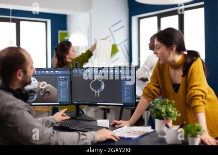 Coworkers engineer working on modern cad program developing industrial metallic construction. Architects designer studying prototype idea on pc showing digital company software with gears Stock Photo