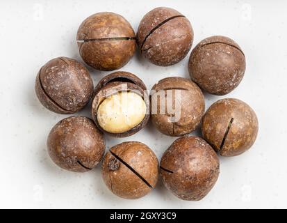 several sawn and shelled macadamia nuts close up on gray ceramic plate Stock Photo