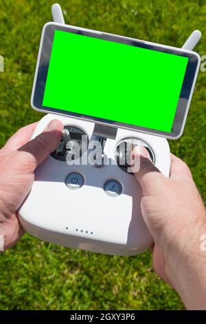 Hands Holding Drone Quadcopter Controller With Blank Green Screen. Stock Photo