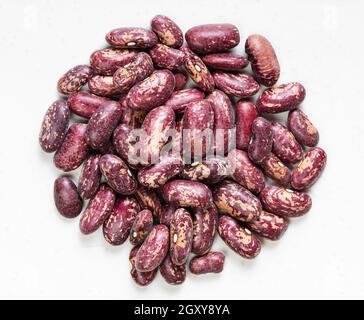 top view of pile of raw red spotted pinto beans close up on gray ceramic plate Stock Photo