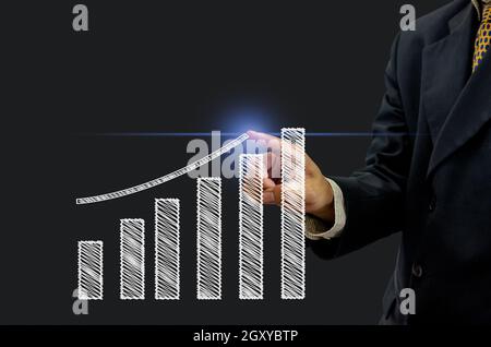 Business man hand is pointing or pressing  graph plan the growth financial icon symbol on virtual screen. Business Investment concept and  technology Stock Photo