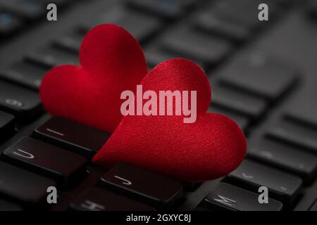 Small red hearts on computer keyboard. Internet dating concept. Stock Photo