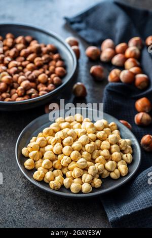 Peeled roasted hazelnut kernels in bowl. Stock Photo