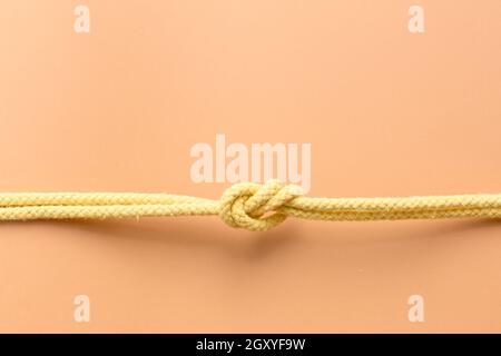 Top view of horizontal knot on orange background. Copy space. Unity concept. Stock Photo