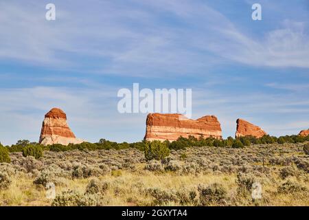 Red rock pillars in open landscape field of green Stock Photo