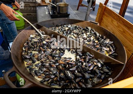 black mussel in a huge pan in Ljubljana dprta kuhna open kitchen outdoor event . Stock Photo