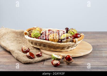 Chestnuts in a basket on a wooden background. Stock Photo
