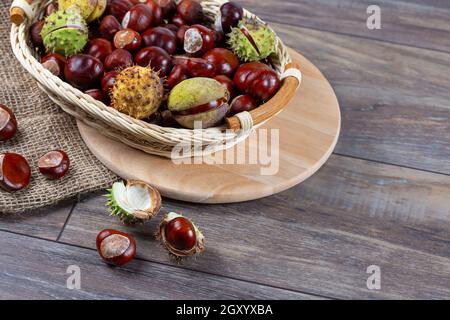 Chestnuts in a basket on a wooden background. Stock Photo