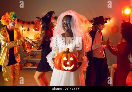Portrait of young cheerful African American woman dressed as zombie bride at Halloween party. Stock Photo