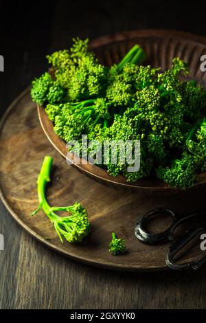 Organic Broccolini (bimi) in bowl on wooden background Stock Photo