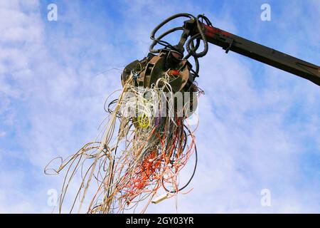 shovel with e-waste, old cables on a landfill sanitary, Austria Stock Photo