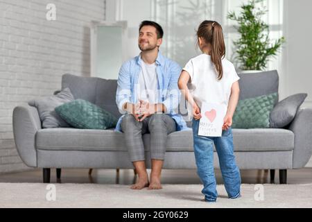 cute child daughter congratulates her father and gives him greeting card. father's day Stock Photo