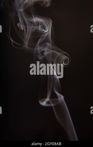 Curling white and gray smoke on a black background Stock Photo