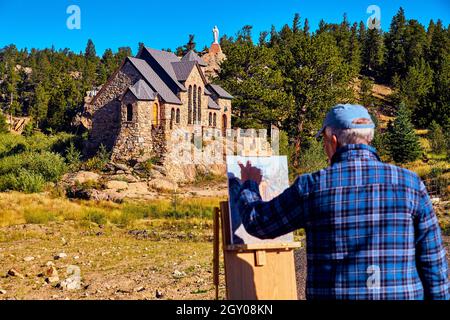 Blurry view of artist paining church focused on church in background desert Stock Photo