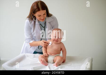 Scared baby being examined with a sterile stethoscope Stock Photo
