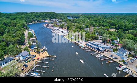 Boats sailing in lake from above with docks and green forest Stock Photo