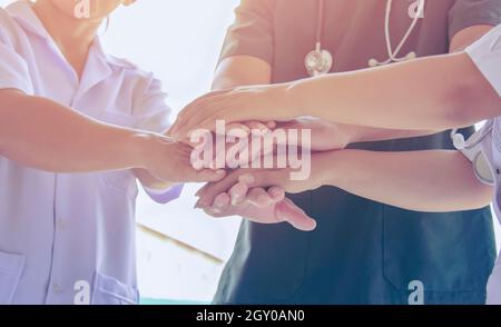 Doctors and nurses in a medical team stacking hands. Surgeon medical people handshaking. Medical personnel in uniform working together in clinic. gree Stock Photo