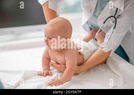 Calm newborn being examined by a female doctor Stock Photo