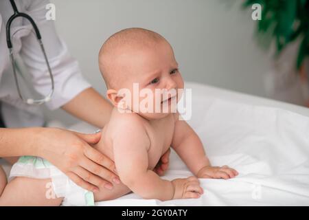 Frightened baby being examined by a healthcare professional Stock Photo