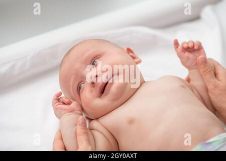 Calm newborn baby being examined by a certified healthcare professional Stock Photo