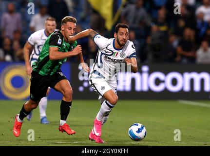 REGGIO NELL'EMILIA, ITALY - OCTOBER 02: Hakan Calhanoglu of FC Internazionale competes for the ball with Davide Frattesi of US Sassuolo ,during the Serie A match between US Sassuolo v FC Internazionale at Mapei Stadium - Citta' del Tricolore on October 2, 2021 in Reggio nell'Emilia, Italy. (Photo by MB Media) Stock Photo