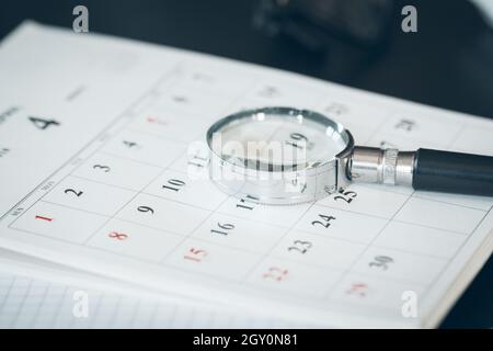 Calendar and Magnifying glass. Concept image of business meetings. Stock Photo