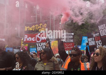 Tory Party Conference protest, Protesters with smoke flare and banner text Institutional Racism. Manchester UK.