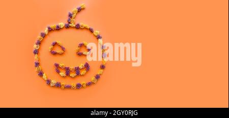 Colorful children's dry pasta for halloween in the shape of a pumpkin on an orange background .Funny food for a holiday for children Stock Photo