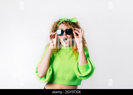 Bright emotional surprised, shocked woman in heart-shaped sunglasses with open mouth isolated on white background. Wow expression. Human emotions, fac Stock Photo