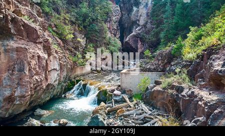 Large canyon with cement wall and waterfall over rocks Stock Photo