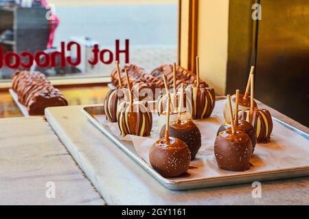 Homemade caramel apples covered in chocolate at fresh chocolate shop Stock Photo