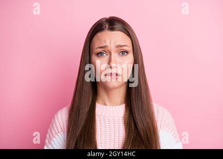 Photo portrait of guilty sad woman biting lip nervous unhappy isolated on pastel pink color background Stock Photo