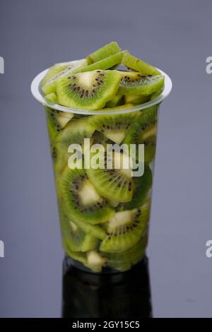 Kiwi fruit slices or cut piece arranged in a glass with black color background. Stock Photo