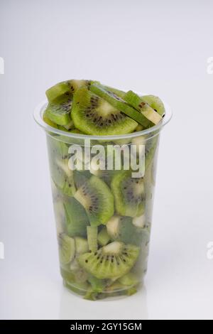 Kiwi fruit slices or cut piece arranged in a glass  with white color background. Stock Photo