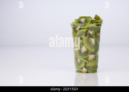 Kiwi fruit slices or cut piece arranged in a transparent glass with white color background. Stock Photo