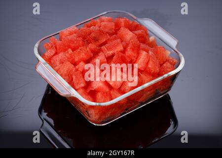 Watermelon Slices,cutpiece  of watermelon arranged in a transparent square glass bowl  with black background, isolated. Stock Photo
