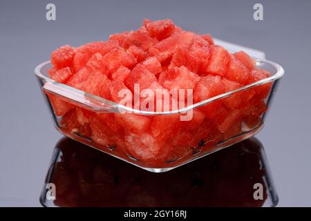 Watermelon Slices,cutpiece  of watermelon arranged in a transparent square glass bowl  with black background, isolated. Stock Photo