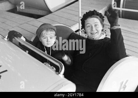Eine Mutter mit ihrem kleinen Sohn auf dem Weihnachtsmarkt, Deutsches Reich 1930er Jahre. A woman with her little son on the Christmas market, Germany 1930s. Stock Photo