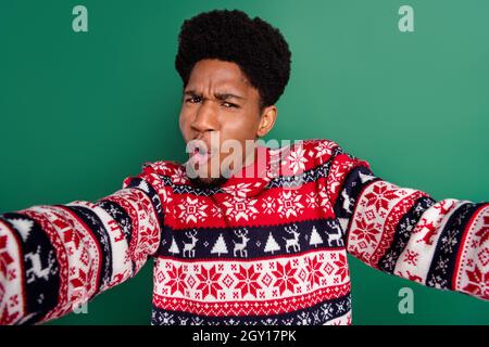 Photo of shocked crazy funny guy make selfie open mouth wear print pullover isolated green color background Stock Photo