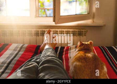 lying and relaxing in bed with cat. Stock Photo