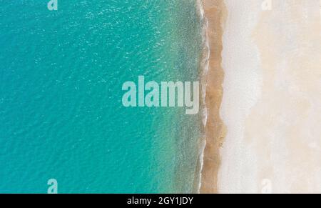 Empty white sand beach and calm turquise sea. Aerial view directly above, background with copy space Stock Photo