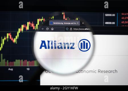 Allianz company logo on a website with blurry stock market developments in the background, seen on a computer screen through a magnifying glass Stock Photo