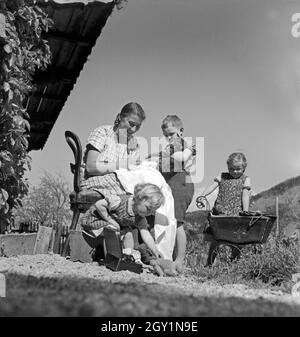 Eine junge Frau kümmert sich um Kleinkinder in Hohenaschau im Chiemgau im Rahmen des Frauenarbeitsdienstes, Deutschland 1930er Jahre. A young woman babysitting toddlers at Hohenaschau at Frauenarbeitsdienst female workforce, Germany 1930s. Stock Photo