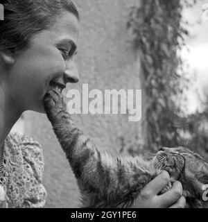 Eine junge Frau spielt mit einer Katze, Deutschland 1930er Jahre. A young woman playing with a cat, Germany 1930s. Stock Photo