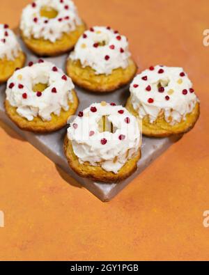 Homemade keto dessert donuts made from almond flour glazed with whipped cream. Gluten-free, low-carb baked goods. Stock Photo