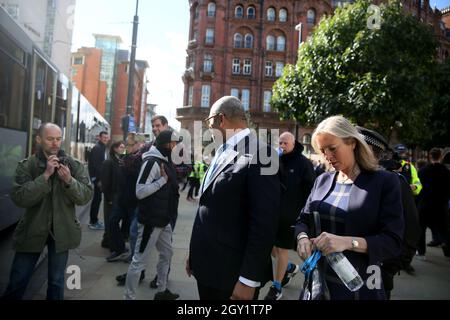 Manchester, UK. 6th October, 2021. James Cleverly,  MP, walks past protesters outside the Tory Party Conference.   Manchester, UK. Credit: Barbara Cook/Alamy Live News Stock Photo