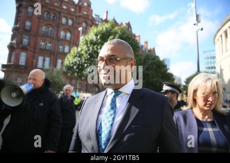 Manchester, UK. 6th October, 2021. James Cleverly,  MP, walks past protesters outside the Tory Party Conference.   Manchester, UK. Credit: Barbara Cook/Alamy Live News Stock Photo