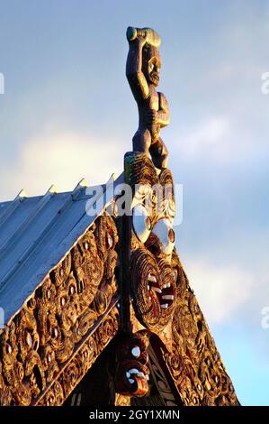 The gable of a Maori Meeting House in Rotorua, New Zealand with its wooden tekoteko representing ancestors, protection, and guardianship over the whare whakairo. Stock Photo