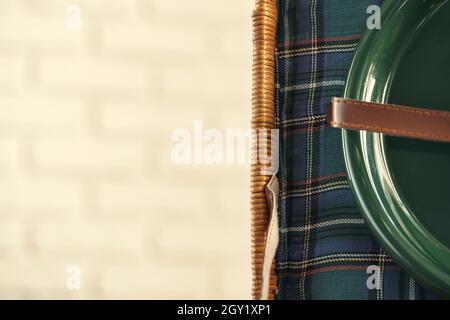 Wooden basket for picnic with plates, cups and silverware close up Stock Photo
