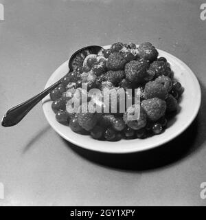 Nahaufnahme eines Tellers mit gezuckerten Himbeeren und Johannisbeeren, Deutschland 1930er Jahre. Closeup view of a plate with raspberries and white currant, Germany 1930s. Stock Photo